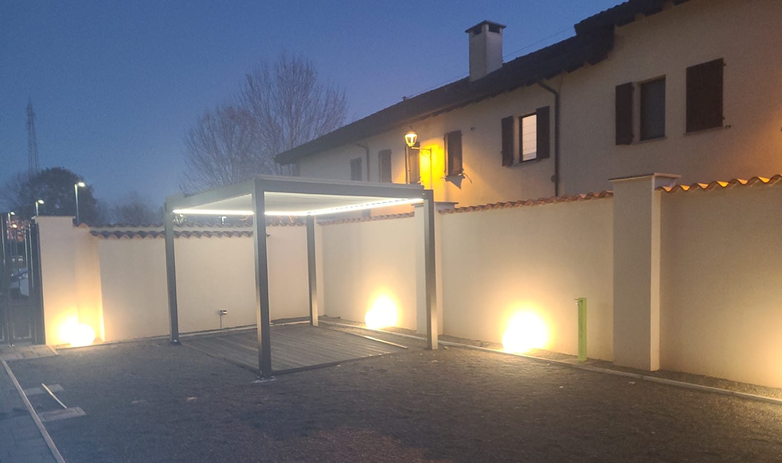 Il cortile completato, con pavimentazione, pergola e illuminazione